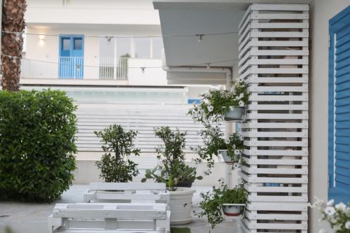 a building with white benches and potted plants at La Scala Suite in Realmonte