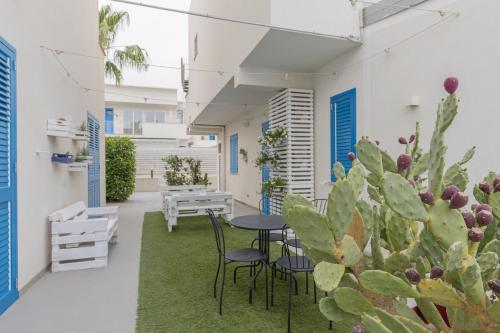 a courtyard with a table and chairs and a cactus at La Scala Suite in Realmonte