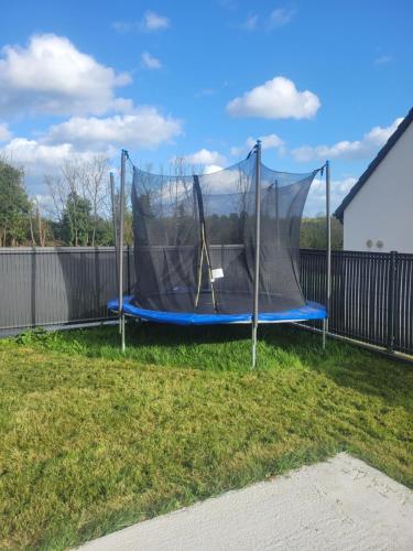 a trampoline in a yard with a net at Chambre d'hôtes Goustranville in Goustranville