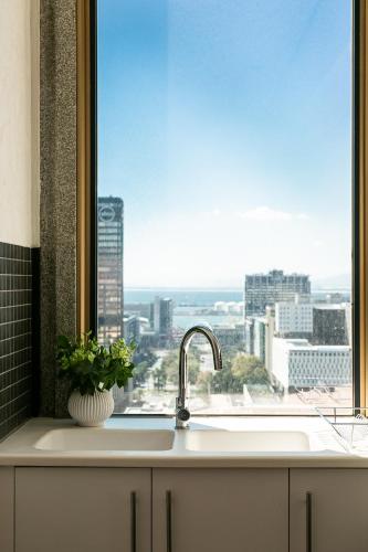 a kitchen sink with a window with a view of a city at #1905 Cartwright - The Spitfire in Cape Town