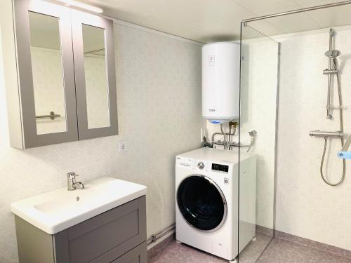 a bathroom with a washing machine and a sink at Viken - Cottage by Dalslands Canal in Dals Långed