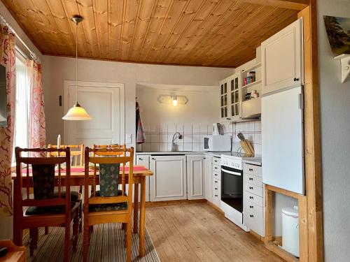 a kitchen with white cabinets and a table with chairs at Viken - Cottage by Dalslands Canal in Dals Långed