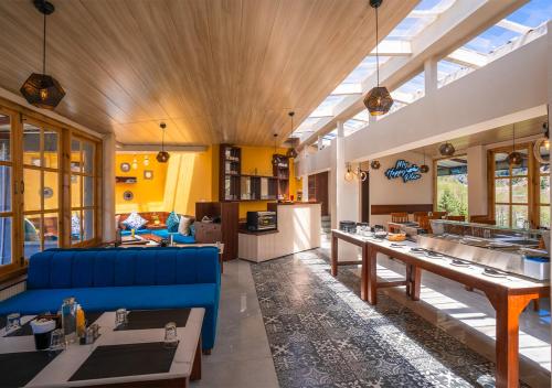a large living room with a blue couch and tables at Moustache Manali in Manāli