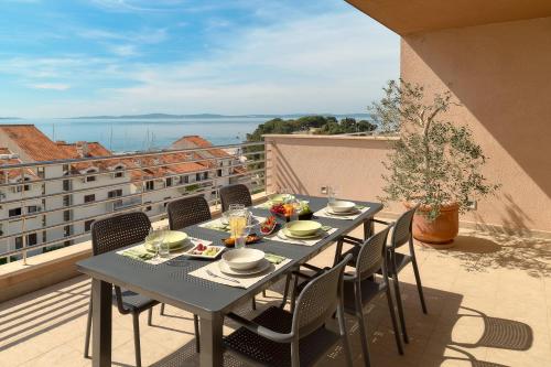 una mesa y sillas en un balcón con vistas en Sun Spalato Penthouse, en Split