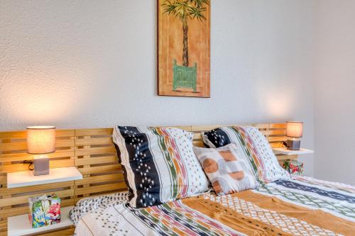 une chambre avec un lit avec des oreillers et deux lampes dans l'établissement Le Bellevue à La Grande Pyramide, à La Grande Motte