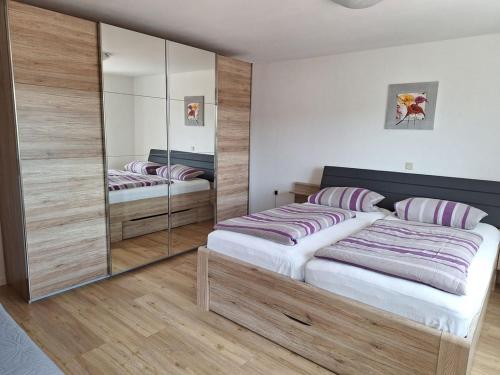 a bedroom with two beds and a mirrored wall at Haus Bergblick Bay. Wald in Prackenbach