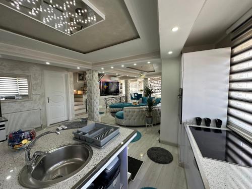 a kitchen with a sink and a living room at Villa By expert VIP in Sarajevo