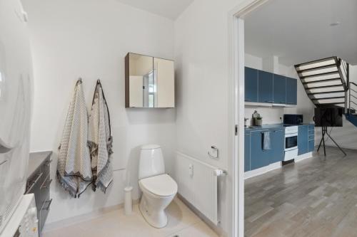 a white bathroom with a toilet and a mirror at Come Stay 2BR -Luxury Apartment 300 m from Magasin in Aarhus