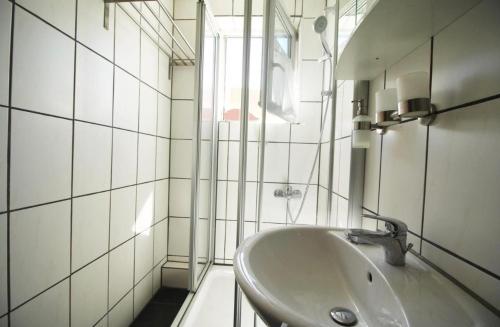 a white bathroom with a sink and a window at home2stay Worker Apartment Merklingen Kitchen Wifi Smart TV Parking in Merklingen