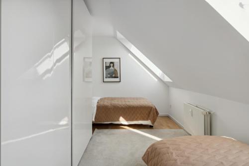 a white room with a bed and a staircase at Come Stay 2BR -Luxury Apartment 300 m from Magasin in Aarhus