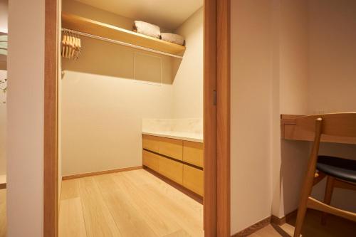 a walk in closet with a sink and a counter at Arima Onsen Takayamaso Hanano in Kobe