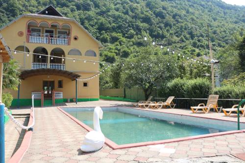 una piscina con un cisne frente a una casa en Grand Hotel, en Khidi