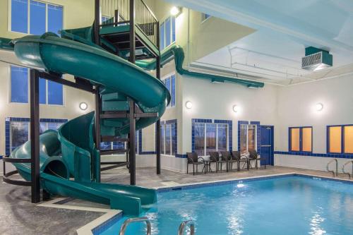 a swimming pool with a slide next to a swimming pool at Ramada by Wyndham Cochrane in Cochrane