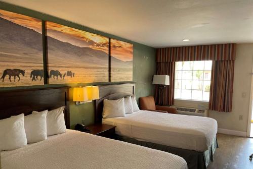 a hotel room with two beds and a painting on the wall at Days Inn by Wyndham Nacogdoches/SFA University/Downtown in Nacogdoches
