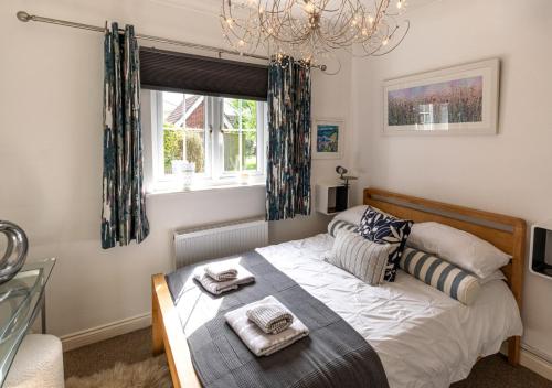 a bedroom with a bed and a window and a chandelier at The Haven in Snape