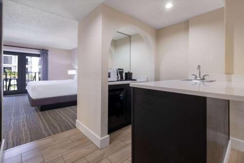 a bathroom with a sink and a bed in a room at Wyndham Boca Raton Hotel in Boca Raton