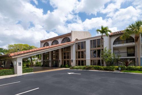an exterior view of a building with a parking lot at Wyndham Boca Raton Hotel in Boca Raton