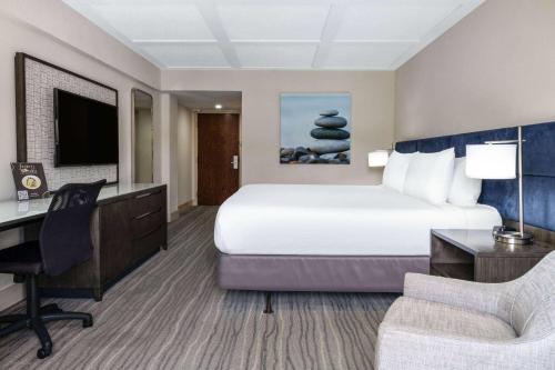 a hotel room with a bed and a desk and a computer at Wyndham Boca Raton Hotel in Boca Raton