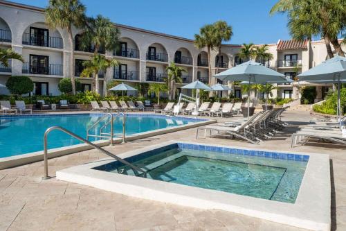 a pool at a hotel with chairs and umbrellas at Wyndham Boca Raton Hotel in Boca Raton