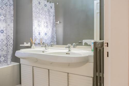 a bathroom with a white sink and a mirror at Appartamento Solatio con 3 camere a Presicce in Presicce