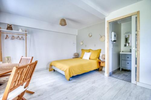 ein Schlafzimmer mit einem gelben Bett und einem Tisch in der Unterkunft gîte ARGOAT Ty Kaouenn in Plumergat