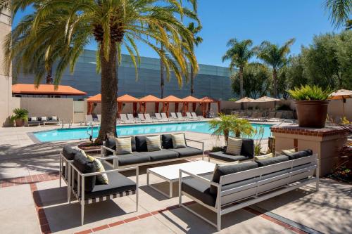 ein Resortpool mit Liegestühlen und Palmen in der Unterkunft Hyatt Regency Santa Clara in Santa Clara