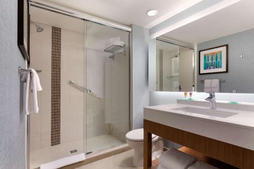 a bathroom with a shower and a sink and a toilet at Hyatt Place Omaha/Downtown-Old Market in Omaha