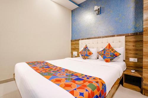 una camera da letto con un letto con un piumone colorato di FabExpress Sara Gold a Mumbai