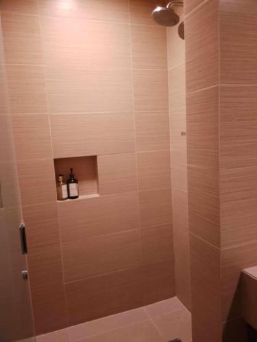 a bathroom with a shower with two bottles on a shelf at 3 BR with 2 BATH - Anvaya Cove Courtyard Unit in Morong