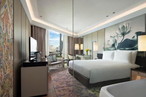 a hotel room with a bed and a desk at Siam Kempinski Hotel Bangkok in Bangkok