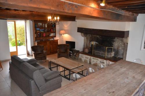 un salon avec une table et une cheminée dans l'établissement Le Hameau du Château Bourgogne Morvan, à Saint-Martin-du-Puy