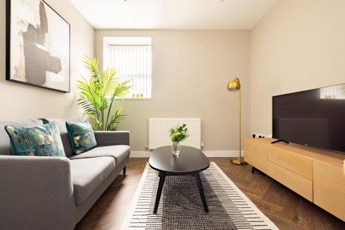 a living room with a couch and a tv at Charles Hope Plymouth in Plymouth
