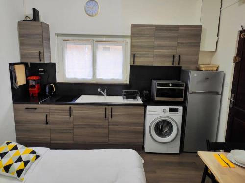 une cuisine avec un réfrigérateur et une machine à laver dans l'établissement Le Rislois des Baquets - Studio moderne et cosy, à Pont-Audemer