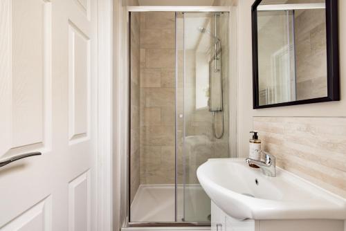 a white bathroom with a shower and a sink at Plymouth by Charles Hope in Plymouth