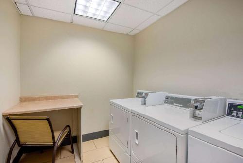 a laundry room with a washing machine and a chair at La Quinta by Wyndham Elkview - Charleston NE in Elkview