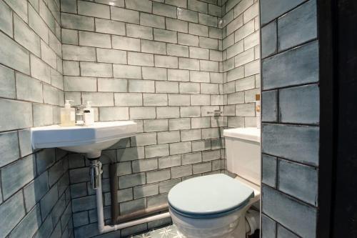 a bathroom with a toilet and a sink at Clifford House - 4 Bed Home Within The City Walls in York