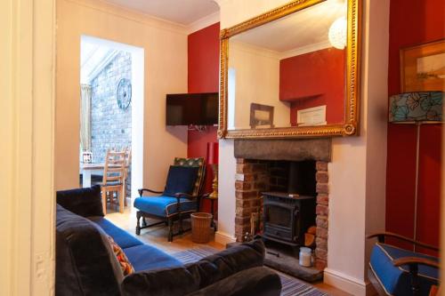 a living room with a couch and a mirror at Clifford House - 4 Bed Home Within The City Walls in York