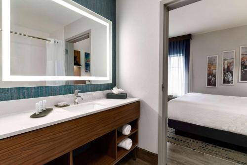 a bathroom with a sink and a bed at La Quinta by Wyndham Stephenville in Stephenville