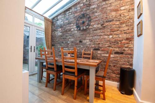 a dining room with a brick wall and a table and chairs at Clifford House - 4 Bed Home Within The City Walls in York