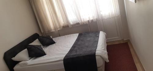 a small bedroom with a bed with a window at AKÇAY LEMAN OTEL in Edremit