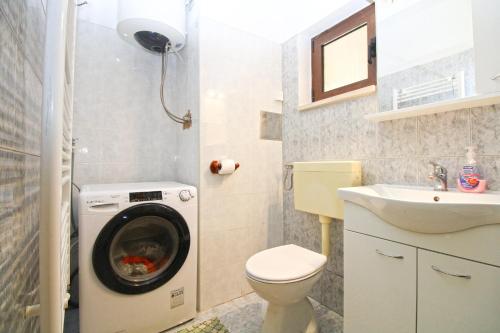 Un baño con lavadora y lavabo. en Apartment Kanfanar 2325, en Kanfanar