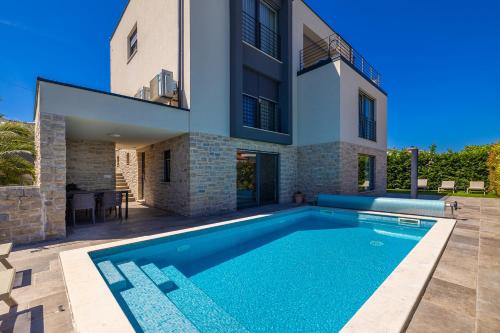 een zwembad voor een huis bij Apartman SIORA in Njivice