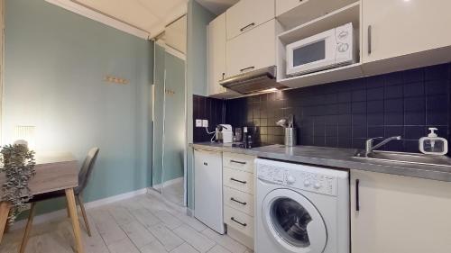une cuisine avec une machine à laver et un évier dans l'établissement Le Vert Neuilly - 10mn Paris, à Clichy