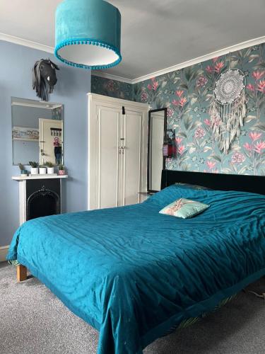 a bedroom with a blue bed with a blue blanket at Large Room sleeps 3 own TV and cereal and toast breakfast in Newhaven in Tarring Neville