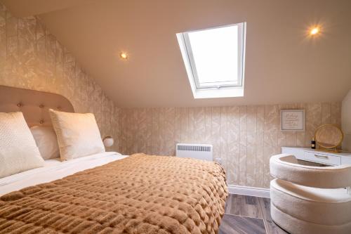 ein Schlafzimmer mit einem großen Bett und einem Dachfenster in der Unterkunft Howfield Hotel in Merthyr Tydfil