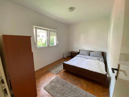 een slaapkamer met een bed en een raam bij Fig City Apartment in Mostar