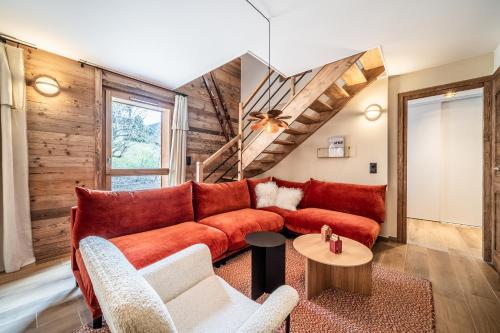 un salon avec un canapé rouge et une table dans l'établissement Apartment Colibri Les Gets - by EMERALD STAY, aux Gets