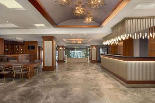 a lobby with a bar and tables and chandeliers at La Quinta by Wyndham Giresun in Giresun