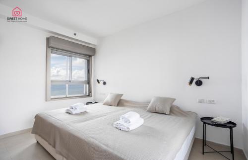 a white bedroom with a bed with towels on it at Luxury apartments' in Netanya in Netanya