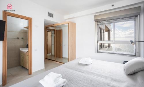 una camera con un letto bianco e una finestra di Luxury apartments' in Netanya a Netanya